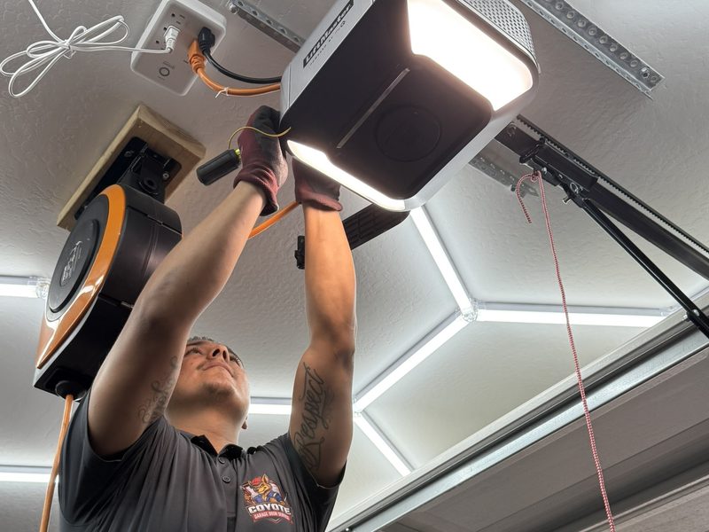 Eric Rivera, owner of Coyote Garage Door Service, mounting a garage door opener
